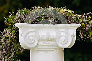 Beautiful flower garland on stone pedestal