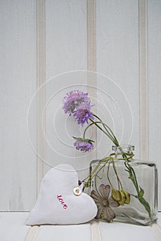 Beautiful flower in vase with heart still life love concept