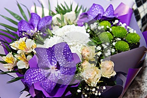 Beautiful flowers bouquet with purple orchids, white roses, lilly, alstroemeria, golden-daisy. A festive concept