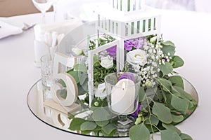 Beautiful flowers in a decorative cage stand on the mirror on the wedding day.
