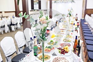 Beautiful flowers on elegant dinner table in wedding day. Decorations served on the festive table in blurred background