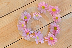 Beautiful flowers in heart shape on wooden background