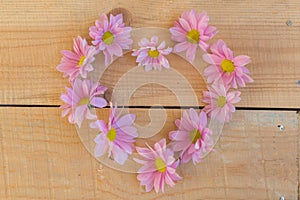 Beautiful flowers in heart shape on wooden background