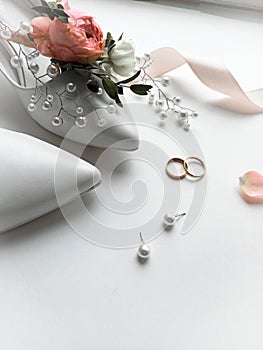 Beautiful  flowers, pearl jewelry and two gold wedding rings on a white background. Marriage concept. Wedding bouquet. Isolated