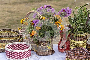 Beautiful flowers in a wicker vase on a table, outdoors, closeup . Bouquet of violet, purple and orange flower. Decoration of home