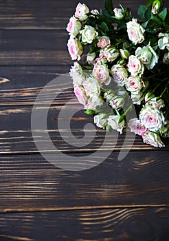 Beautiful flowers on wooden background. Roses bouquet. Perfect flat lay with petals. Happy mother`s holiday postcard.