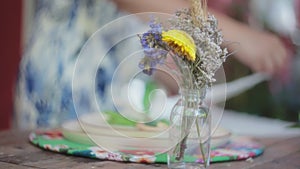 Beautiful flowery decorations on a wooden dining table outdoors