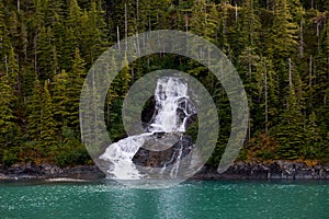 Beautiful flowing waterfall into the ocean in Endicott Arm, Alaska