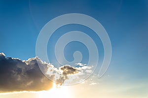 Clouds and sun in a blue sky at sunset