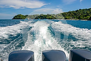 A beautiful foamy trail from a boat with three powerful engines, leaving from Banana Beach of Coral Koh He Island, Thai