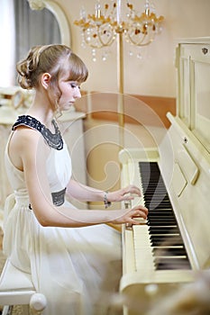 Beautiful focused girl in white dress plays white photo
