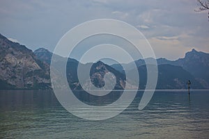 Beautiful foggy and cloudy landscape with a lake and mountains in summer.