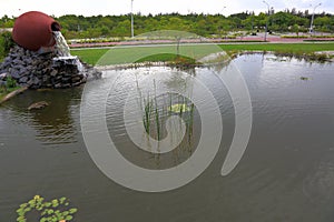 Beautiful fontain formed as ceramic jar in a park. Beautiful nature background.