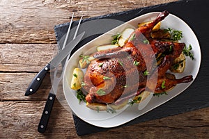 Beautiful food: baked whole duck with apples close-up on a platter. horizontal top view