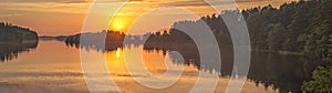 Beautiful forest lake in the evening sunlight. Panorama