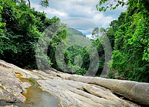 Beautiful forest and mountain with blue sky and white cumulus clouds. Tropical green tree forest. Nature background.  Granite rock