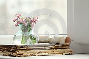 Beautiful Forget-me-not flowers and old book on window sill. Space for text