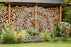 Beautiful formal garden with flowers and fire wood storage