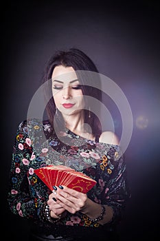 Beautiful fortune teller wondering on the Tarot cards.