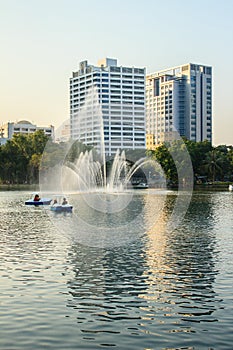 Beautiful fountains in the lake at Lumpini Park, Bangkok Thailand. Tranquil public park garden with pond, fountain, and boats in