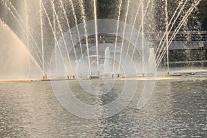 Beautiful fountains in the lake at Lumpini Park, Bangkok Thailand. Tranquil public park garden with pond, fountain, and boats in