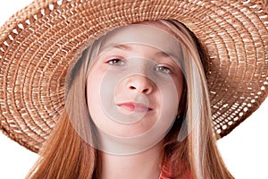 Beautiful freckled young girl wearing straw hat