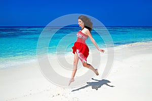 Beautiful free girl running on exotic beach with white sand and