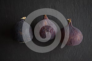 Beautiful fresh blue violet figs on dark stone background