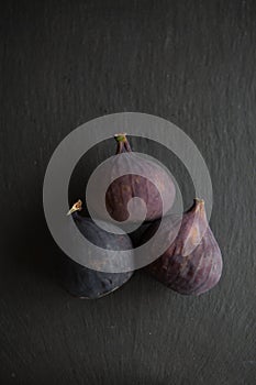 Beautiful fresh blue violet figs on dark stone background