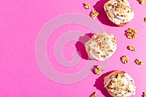 Beautiful fresh cinnamon rolls close-up on pink paper background hard shadow