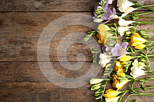 Beautiful fresh freesia flowers on wooden background