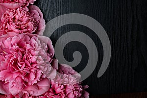 beautiful fresh peonies on wooden surface. Floral frame with pink peonies on wooden background