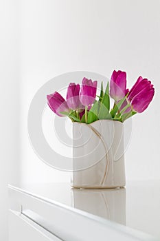 Beautiful Fresh Spring lila Tulips in Vase on bright background. photo