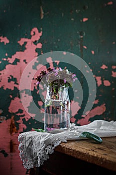 Beautiful fresh summer still life with a bouquet of wildflowers in a glass jar. Still life in a rustic style against a dark