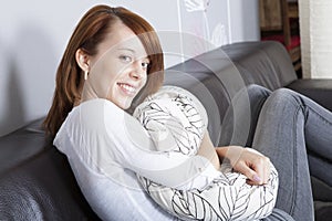 Beautiful friendly woman hugging a cushion