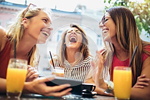 Beautiful friends in a cafe using tablet pc and having fun