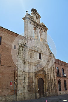 Beautiful Front Facade Of The Church Of Alcala De Henares University With A Nest Of Storks In Its Old Bell Tower. Architecture Tra