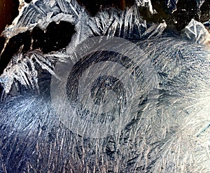 Beautiful frostwork on a window glass as an abstract winter background blue white ice stripes, frost pattern