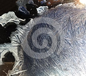 Beautiful frostwork on a window glass as an abstract winter background blue white ice stripes, frost pattern