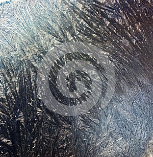 Beautiful frostwork on a window glass as an abstract winter background blue white ice stripes, frost pattern, hoarfrost. For