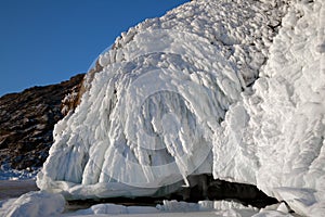 Beautiful frozen formations of white ice on mountain rock