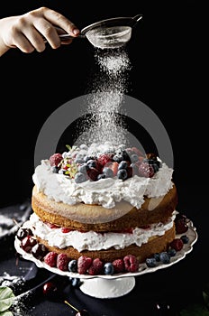 Beautiful, fruit naked cake on a dark tablecloth
