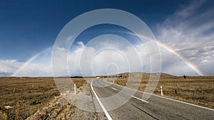 Beautiful full double rainbow over road
