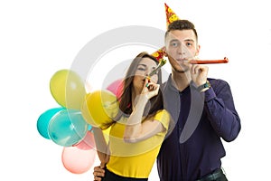 Beautiful and funny girl with boyfriend celebrate birthday hold balls and blow horns