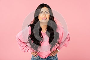 Funny girl sticking tongue out isolated on pink