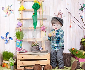 Beautiful funny little boy playing among easter spring scenery.