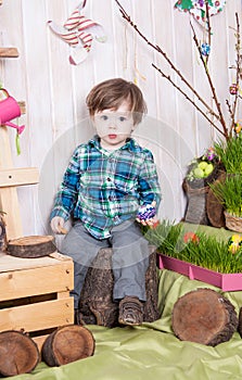 Beautiful funny little boy playing among easter spring scenery.