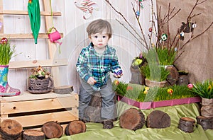 Beautiful funny little boy playing among easter spring scenery.