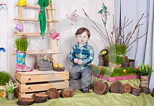 Beautiful funny little boy playing among easter spring scenery.