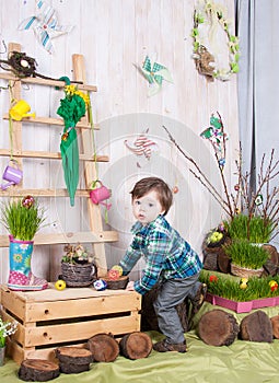 Beautiful funny little boy playing among easter spring scenery.